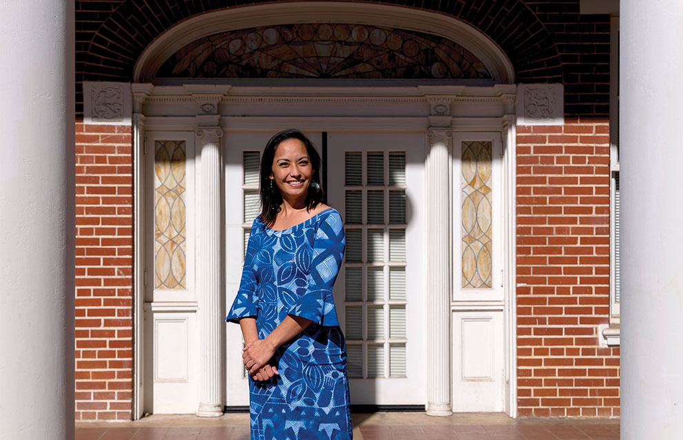 a person in a blue dress standing in front of a brick building