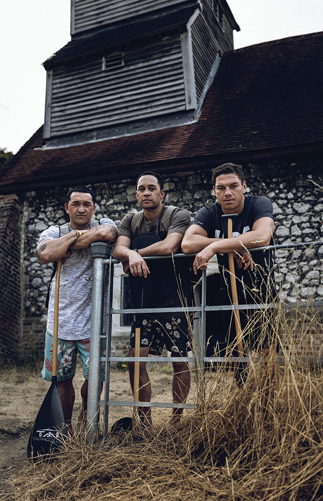 a group of men leaning on a fence