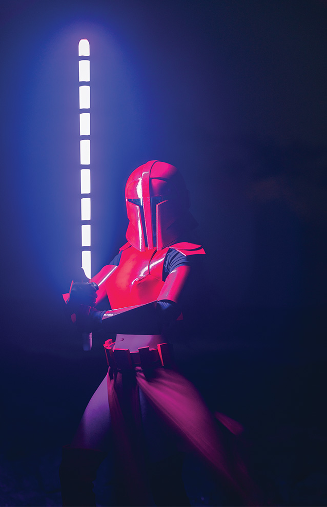 a person in a red space suit costume holding a light saber