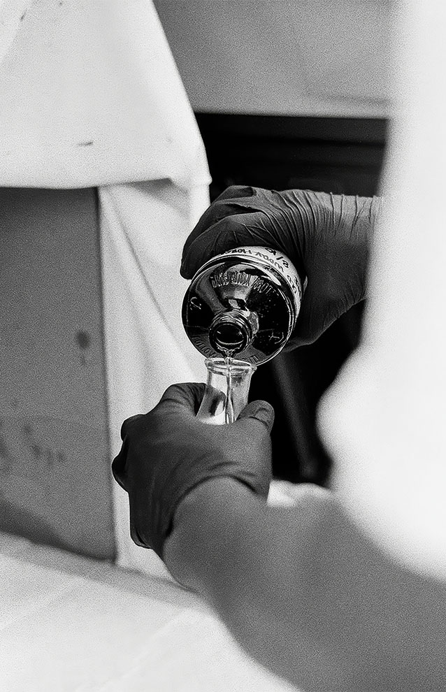 a closeup of a person filling up a glass bottle