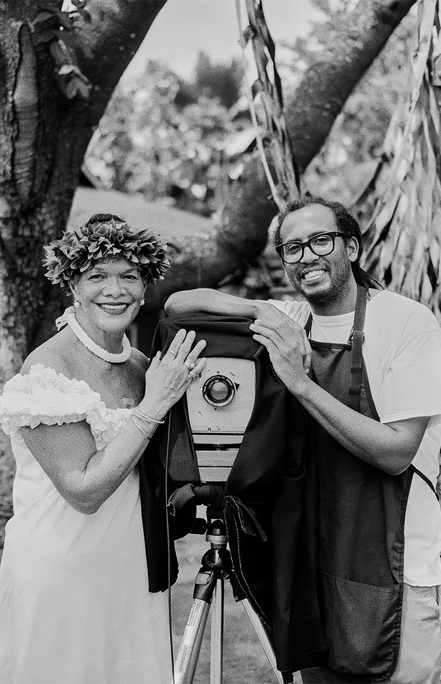 two people posing beside an old camera