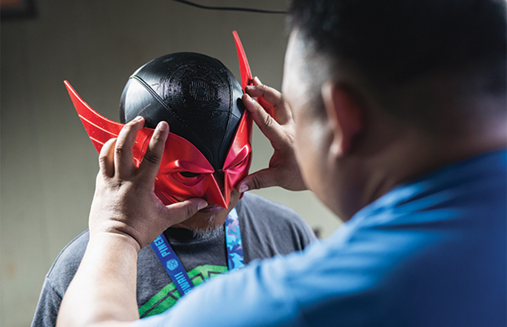 a person putting a costume mask on a child