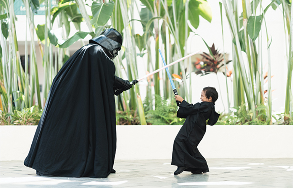 a person and a child in costume pretending to duel with swords