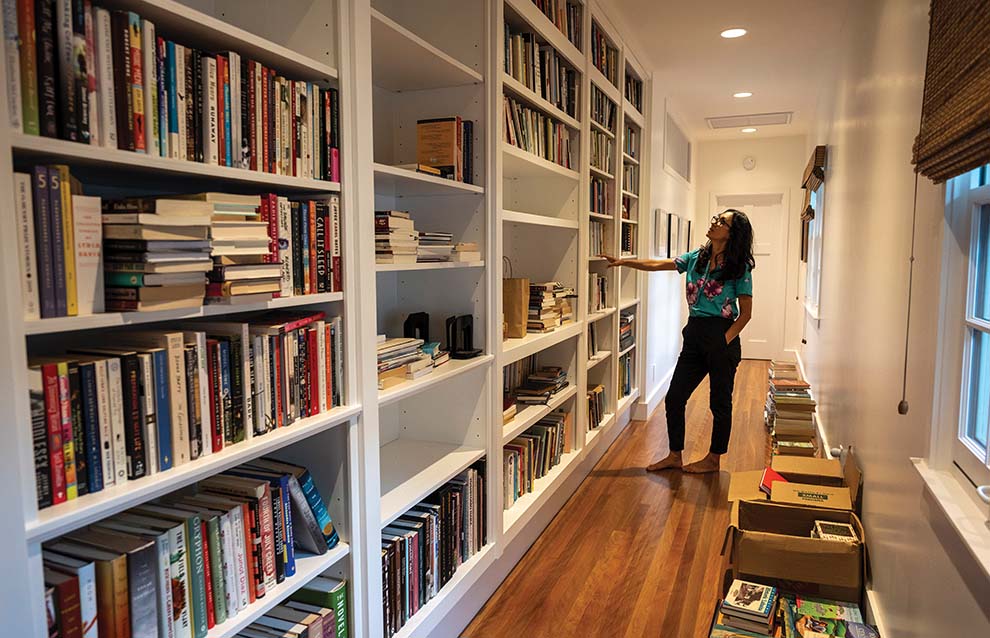 a person standing beside bookcases full of books