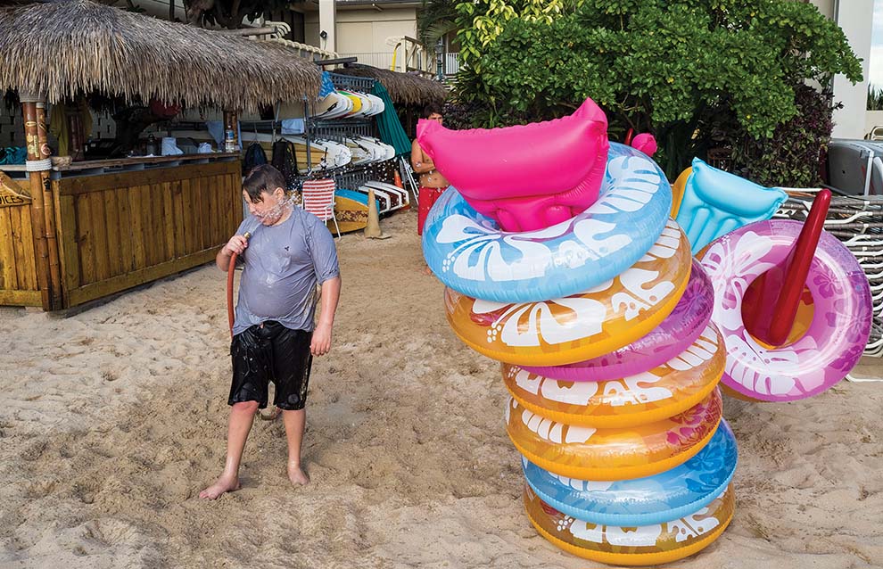 a person stands beside a donut sculpture