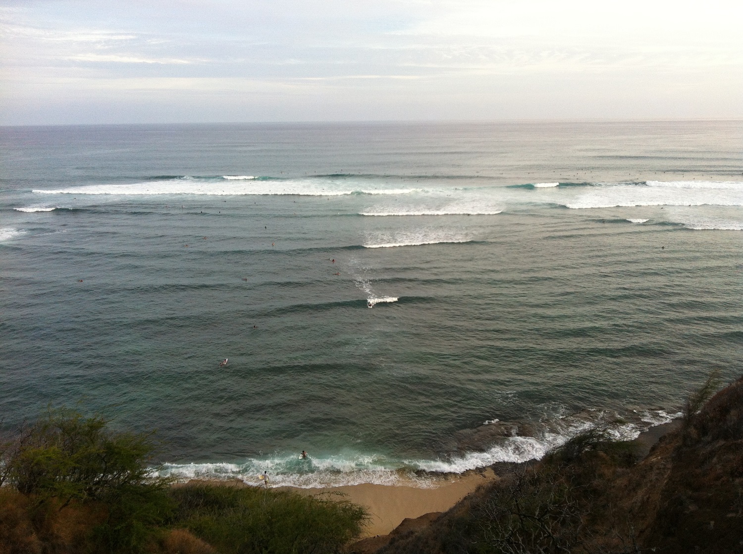 Surfers near Diamond Head cliffs